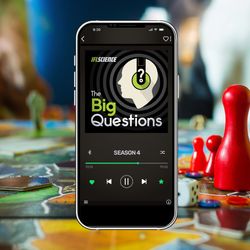 a smartphone playing an episode of The Big Questions, with people playing games in the background