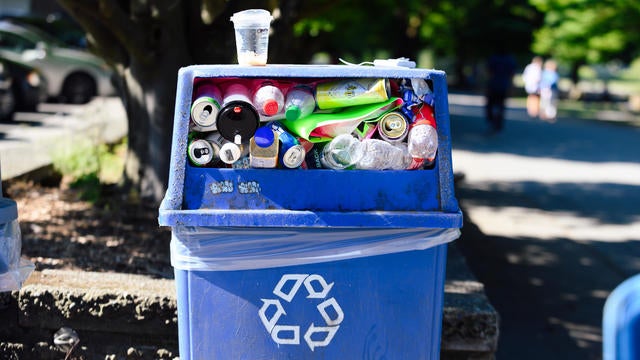 Blue plastic recycling bin full of bottles and cans 