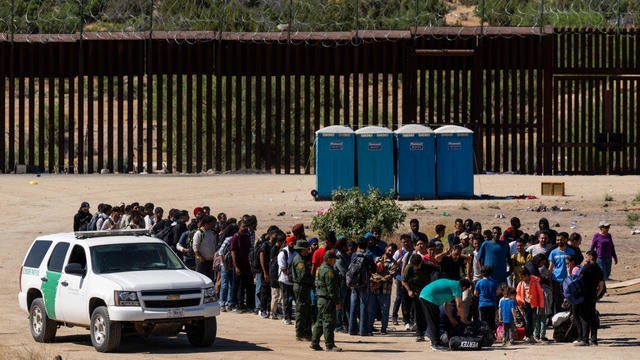 Migrants wait to be processed by U.S. Border Patrol agents after crossing into the U.S. from Mexico on June 14, 2024, in Jacumba Hot Springs, California. 