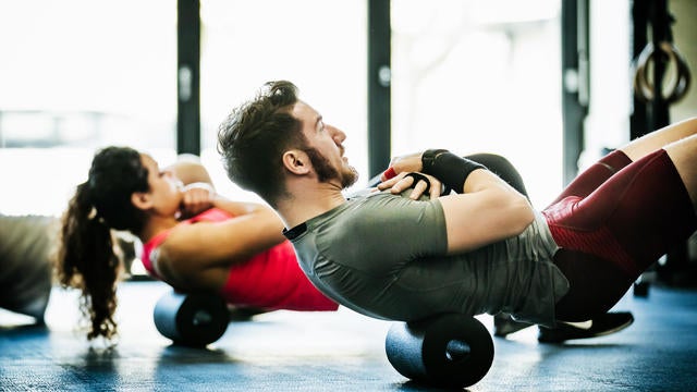 Gym Goers Performing Floor Exercises Together 