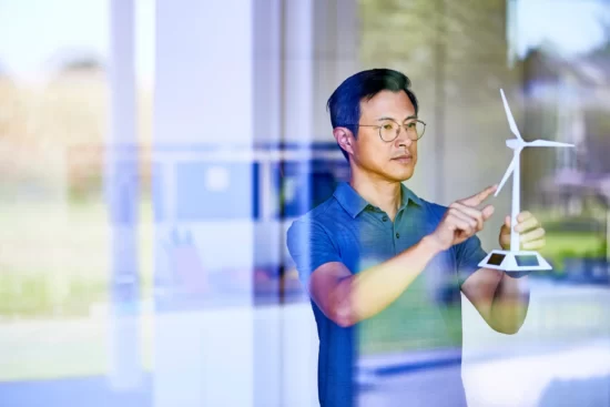 A person and person looking at a wind turbine