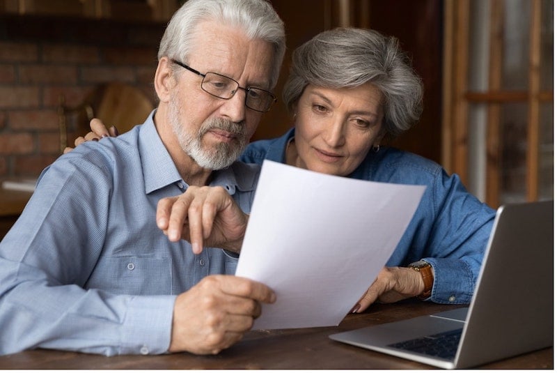 An elderly couple are researching about the cost of installing solar panels.