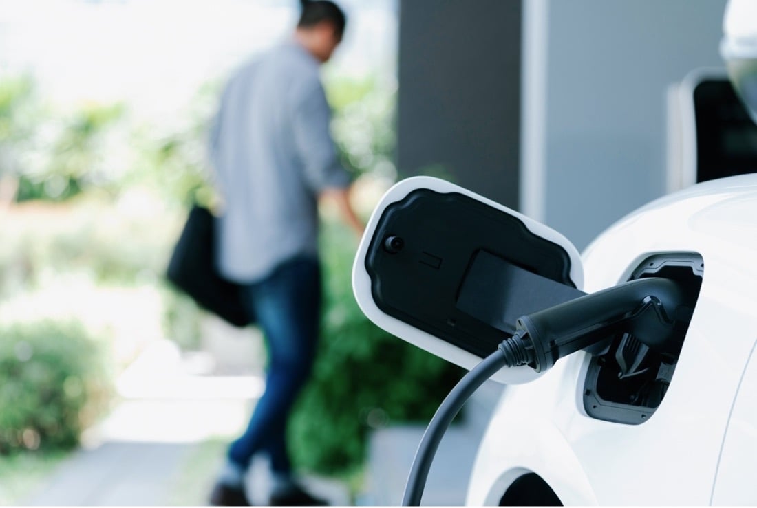 A man is charging his EV after he arrives home.