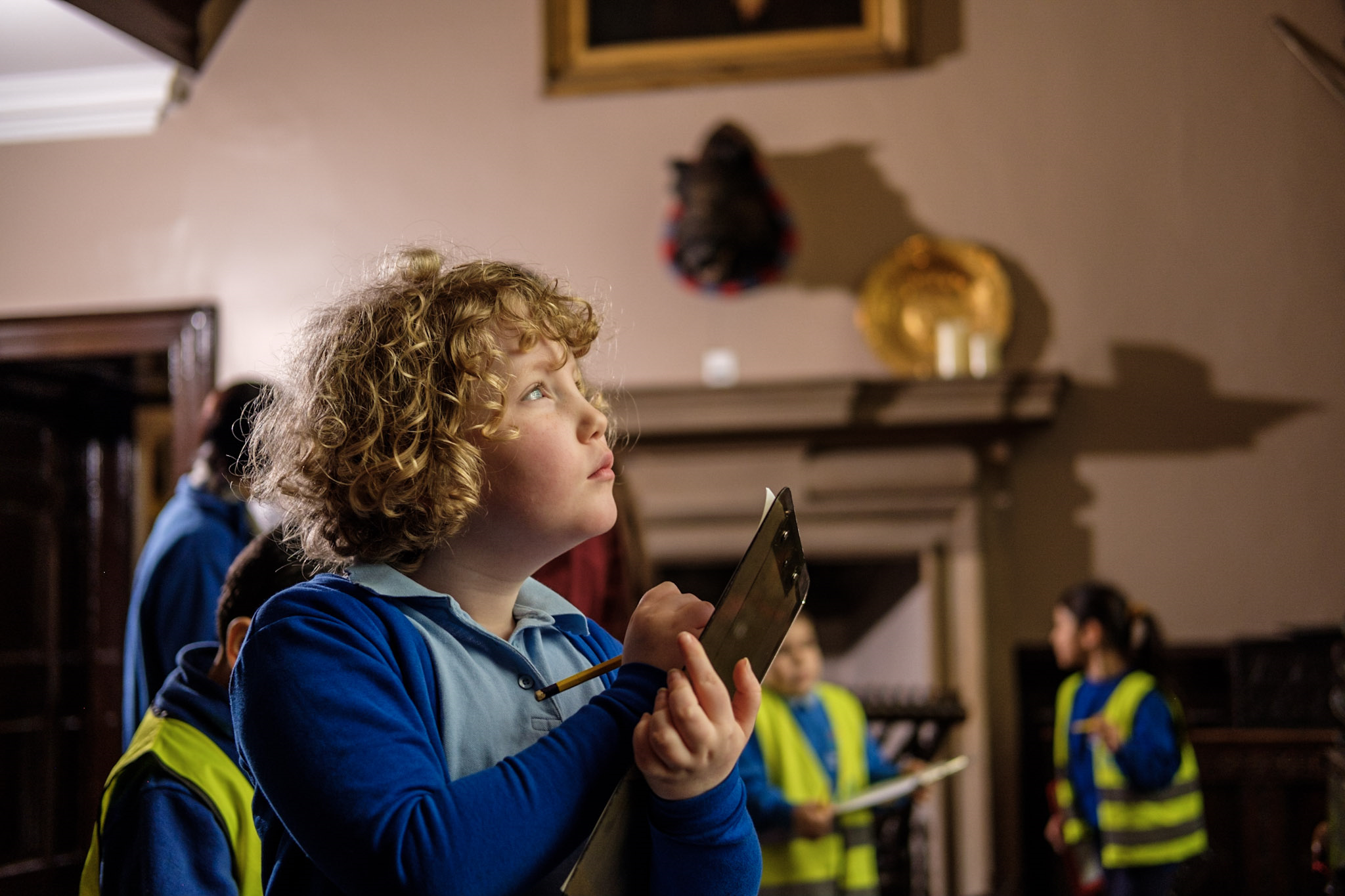 Image shows a young girl with a clipboard in the housebody at Bolling Hall