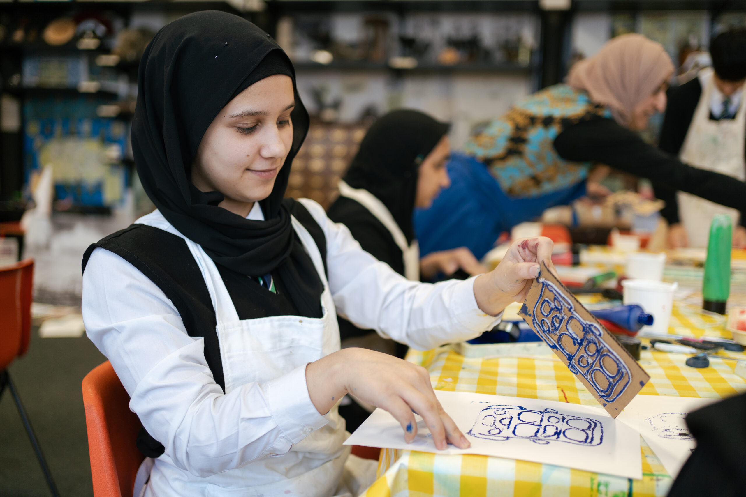 Girl, wearing an apron taking part in an printing activity