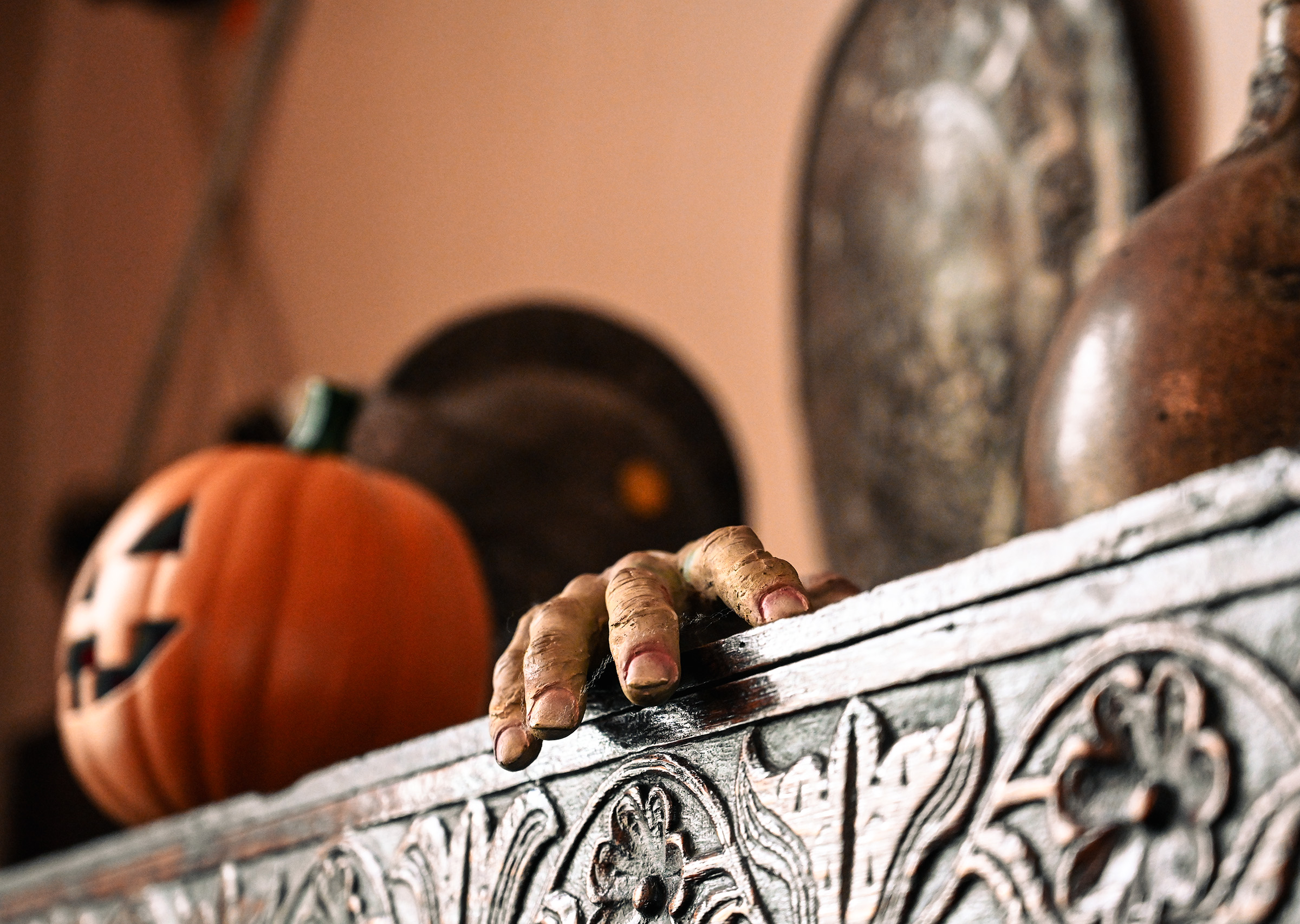 a creepy hand and a pumpkin jack o lantern on top of a wooden dresser in Bolling Hall