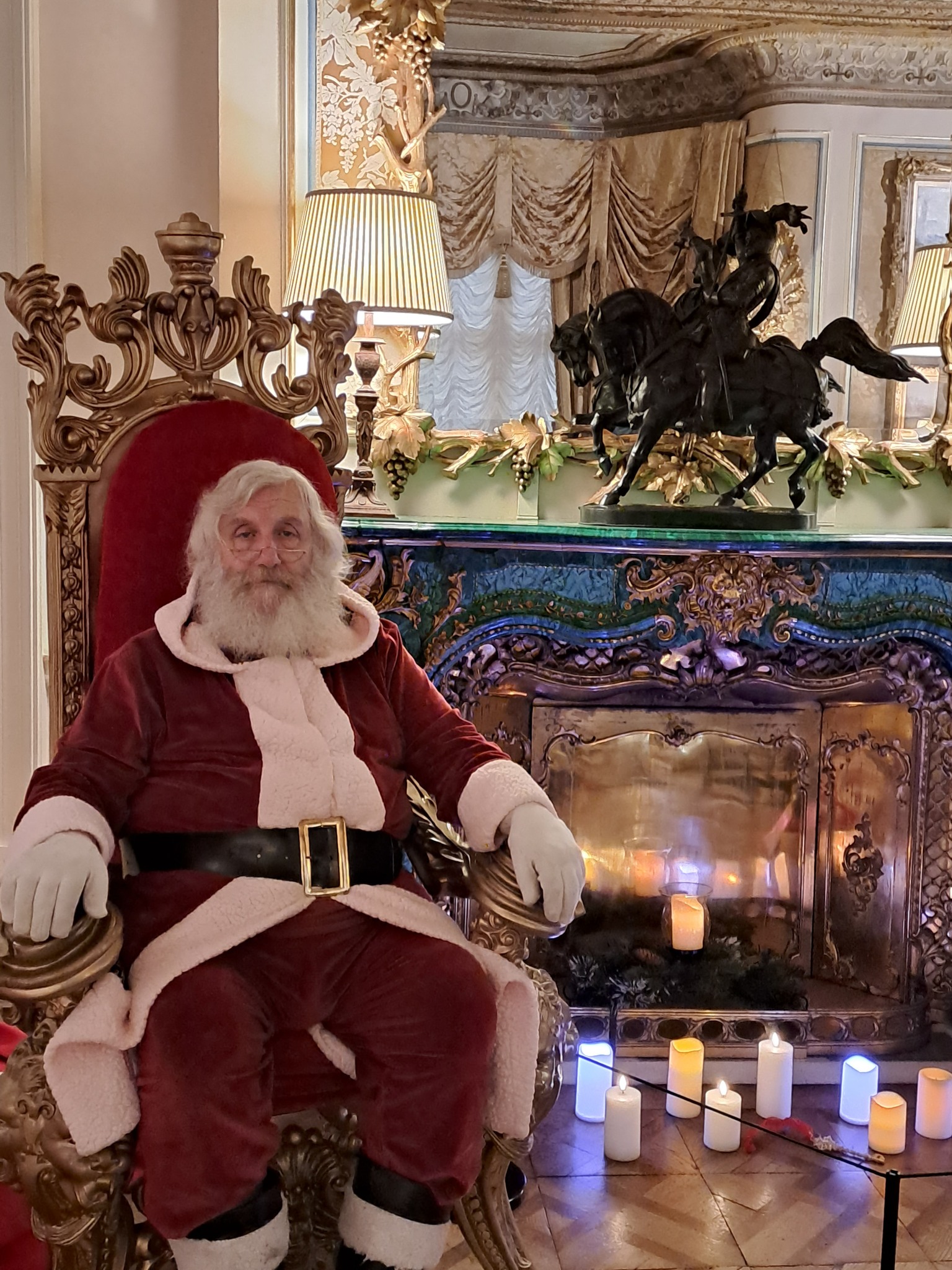 Father Christmas, sat in front of a green and gold Malachite chimney piece