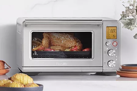 the Smart Oven® Air Fryer on bench with delicious food