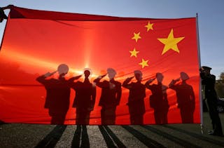 Retired paramilitary policemen, who conduct the daily national flag raising and lowering ceremony on Tiananmen Square, salute to