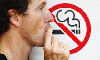 man smoking a no-smoking sign