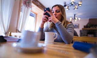 Smartphone addicted girl using device on a date or internet dating application concept — Photo by guteksk7