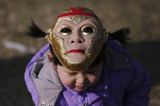 A girl wearing a monkey mask atop her head is seen at the Longtan park as the Chinese Lunar New Year is celebrated in Beijing