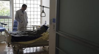 Doctor Stephane Mercier visits a patient at the palliative care unit of the AP-HP Paul-Brousse hospital in Villejuif near Paris