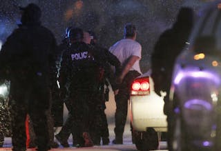 The handcuffed suspected gunman at the Planned Parenthood clinic is moved to a police vehicle in Colorado Springs, Colorado