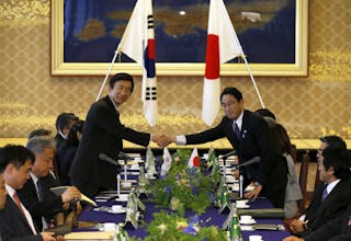 South Korea's Foreign Minister Yun Byung-se shake hands with Japan's Foreign Minister Fumio Kishida before their meeting in Toky