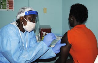 Health worker injects a woman with an Ebola vaccine during a trial in Monrovia