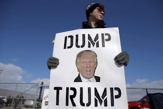 A protestor demonstrates outside a campaign rally for U.S. Republican presidential candidate Donald Trump in Cadillac