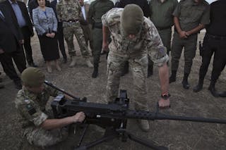 British soldiers train Kurdish Peshmerga fighters on how to use a heavy machine gun in Arbil