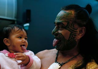 New Zealand's ethnic Maori Metini Mitai Ngatai and his son Niwareka joke prior to the official opening of the book fair in Frank