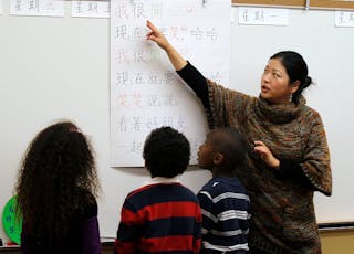 Teacher Kennis Wong points to Chinese characters on a board at Broadway Elementary School in Venice, Los Angeles