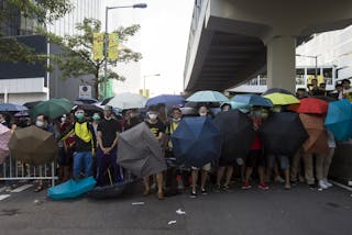 Protesters carry umbrellas to try to protect themselves from being pepper-sprayed during a confrontation with the police after a