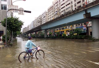 A BICYCLIST MAKES HIS WAY THROUGH A FLOODED STREET IN TAIPEI.