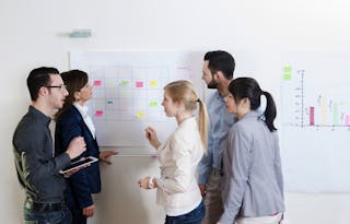 Group of young business people and businesswoman in discussion in office, using whiteboard, Germany