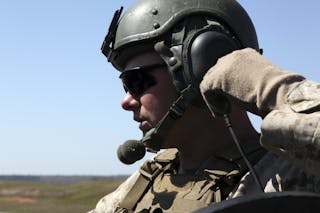 A soldier keeps in radio contact with the range tower during an exercise.