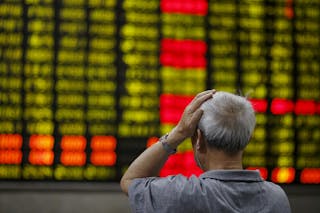 Investor looks at an electronic board showing stock information at a brokerage house in Shanghai