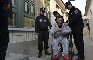 A man cries in front of his home as policemen enforce a court order to remove him from a hospital in Beijing