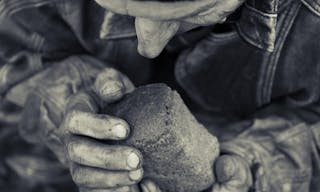 A loaf of bread in an old man's hands