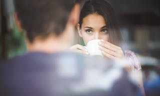 Young couple on first date drinking coffee, shot through window glass. — Photo by ninann