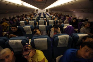 Passengers remain in their seats onboard Malaysia Airlines Boeing 777-200ER flight MH318 as it cruises towards Beijing over the 