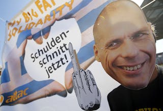 A demonstrator sporting the mask depicting former Greek Finance Minister Varoufakis takes part in a protest outside the European