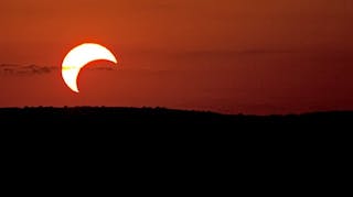 Partial solar eclipse during sunset.