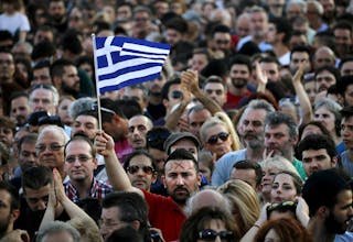 A protester sports the word 'No' in Greek on his forehead as he waves a Greek flag during an anti-austerity demonstration in Syn