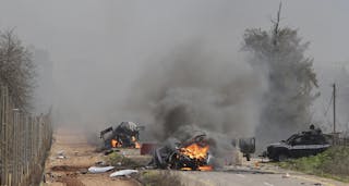 Burning vehicles are seen near the village of Ghajar on Israel's border with Lebanon