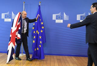 Members of protocol adjust the British and EU flags prior to the arrival of British Prime Minister David Cameron at EU headquarters in Brussels on Tuesday, June 28, 2016. EU heads of state and government meet Tuesday and Wednesday in Brussels for the first time since Britain voted to leave the European Union, throwing British and European politics into disarray. (AP Photo/Geert Vanden Wijngaert)