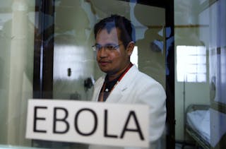 A doctor stands in an isolation room  during a media tour displaying the government's measures in preparing against Ebola at the