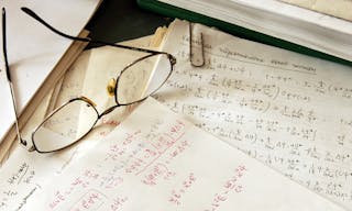 glasses over physics formulas and calculations written on paper