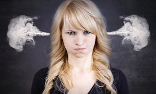 Closeup portrait angry young woman, blowing steam coming out of ears, about to have nervous atomic breakdown, isolated black bac