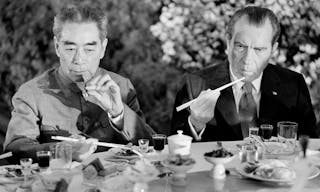 U.S. President Richard Nixon, right, is serious-faced as he eats with chopsticks in Shanghai, China, on Sunday, February 28, 197