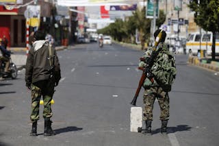 Houthi fighters operate a checkpoint on a street leading to the Presidential Palace during clashes in Sanaa