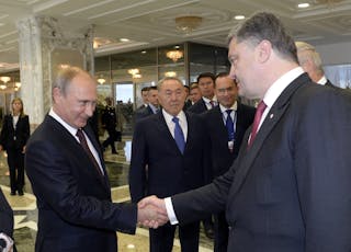 Russian President Vladimir Putin shakes hands with his Ukrainian counterpart Petro Poroshenko in Minsk