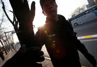 A policeman stops media outside the Beijing No. 1 Intermediate People's Court, where Xu Zhiyong's trial is held, in Beijing