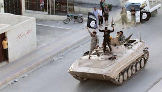 Militant Islamist fighters take part in a military parade along the streets of northern Raqqa province