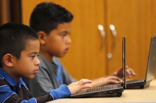 Grade four students work on laptop computers at Monarch School in San Diego, California