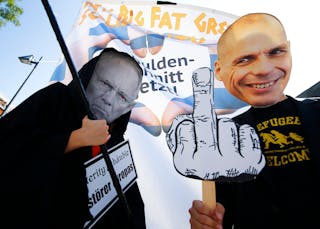 Demonstrators sporting the masks depicting German Finance Minister Schaeuble and former Greek Finance Minister Varoufakis take p