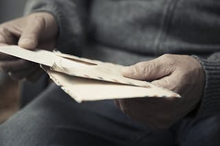 信＿Senior man reading old letters