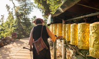 Dharamsala, India - June 9, 2017: Unidentified tibetan woman spinning prayer wheels in Dharamsala, India